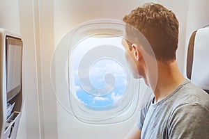 Passenger of airplane looking at window, travel by plane