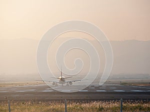 Passenger airplane on runway airport at sunset