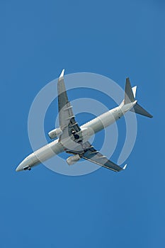 Passenger airplane. View exactly from below, silhouette against the blue sky.