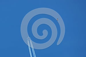 Passenger airplane. View exactly from below, silhouette against the blue sky.