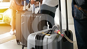 Passenger with big roller luggage standing on the line waiting for taxi queue at taxi parking lot at airport arrival terminal