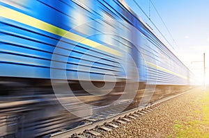 Passenger blue wagons at a speed passing railway.