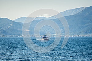 Passenger boat ferry on the sea. Ferry boat leaving the land behind