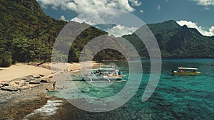 Passenger boat at ocean beach aerial view. People resting, swiming on sand at sea bay water scape