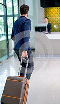 The passenger business man hurry to bring his bag go straight on counter service of airline in the airport