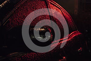 passenger car  covered with ice and illuminated by deep red light