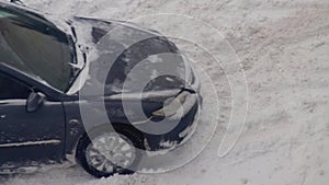 A passenger car got stuck in the snow. Wheels skid in snow on ice, close-up, wheelspin