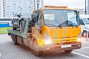 Passenger car loaded onto a recovery truck for transportation.