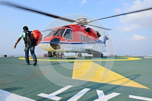 Passenger carry his baggage to embark helicopter at oil rig plat photo
