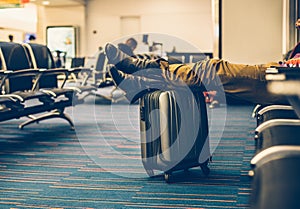 Passenger with carry on luggage waiting for the delay flight in the airport terminal