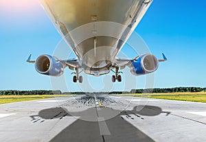 Passenger close up bottom airplane fly over the runway in good weather.