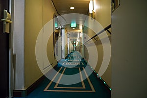 Passenger deck hallway with living cabins rooms on board of cruise ship