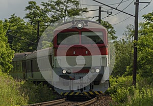 Osobní diesel červený velký vlak poblíž stanice Kysak v letním horkém ránu