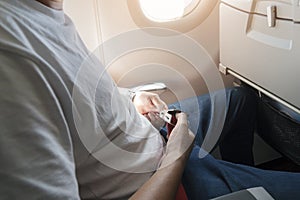 Passenger fastening seat belt while sitting on the airplane for safe flight. Safety travel