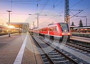 Passenger high speed train on the railway station at sunset