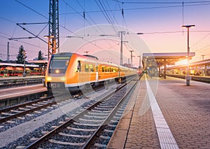Passenger high speed train on the railway station at sunset