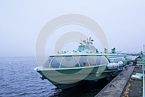 Passenger hydrofoil boat on the docks of Onego lake in foggy weather.