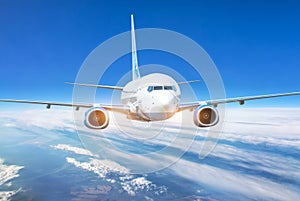 Passenger jet plane in the blue sky. Aircraft flying high through the cumulus clouds. Close up view airplane in flight