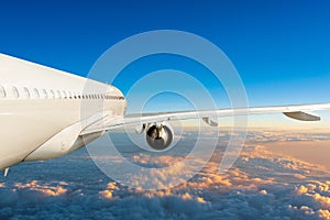 Passenger jet plane in the blue sky, unique side view. Aircraft flying above the cumulus clouds. Airplane travel concept
