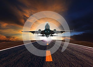 Passenger jet plane flying over airport runway against beautiful