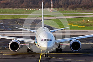 passenger plane arriving at an airport and taxiing to the terminal gate