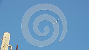 A passenger plane flies in a blue cloudless sky.