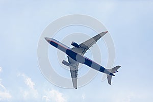 Passenger plane flies in the blue sky with clouds. Aviation industry