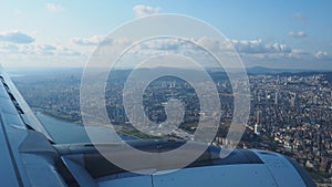 A passenger plane flies over Istanbul, the capital of Turkiye. Houses, streets, roads of Istanbul. Aircraft engine