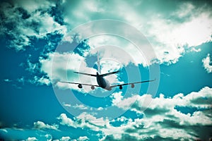 Passenger plane in flight. Aircraft fly high in the blue sky over the clouds. Side view of aircraft