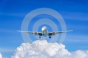 Passenger plane in flight. Aircraft fly high in the sky above the clouds. Front view of airplane