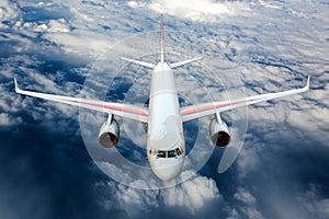 Passenger plane fly high in the sky above the clouds. Front view