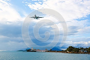 Passenger plane flying over beautiful blue ocean and island in purity destination sea beach use for summer holiday vacation