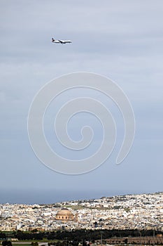 A passenger plane is landing flying over the old center of the Maltese city.