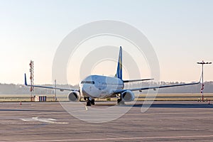 Passenger plane on a long parking lot in a small airport, morning light.