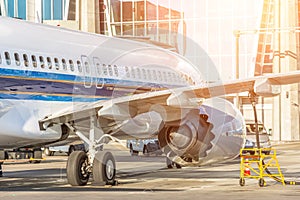 Passenger plane is parked in front of the terminal for preflight maintenance and fueling