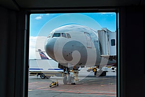 A passenger plane is standing at the airport in a parking space awaiting departure, the process of preparing for the flight is in