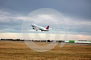 Passenger plane takes off from the airport runway. Side-view of aircraft