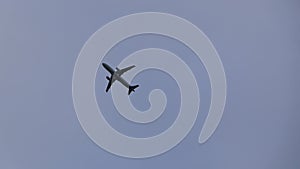 A passenger plane took off at the airport and is gaining altitude, flying over the photographer against a cloudy sky