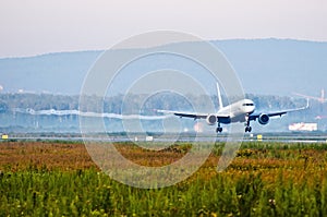 Passenger plane before touching runway landing with vortexes coming from wingtips.