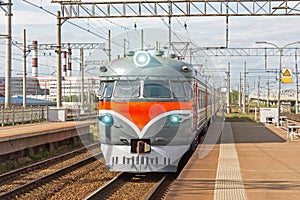 Passenger retro electric train at the station near the railway.