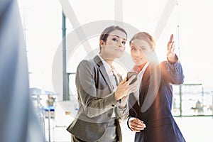 Passenger service agent assisting and giving directions with businesswoman in airport