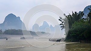 passenger ships in mist over river near Xingping