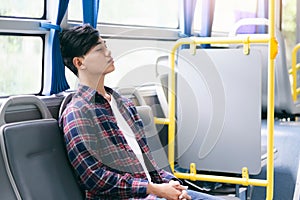 Passenger sitting and sleeping inside a public bus while traveling.