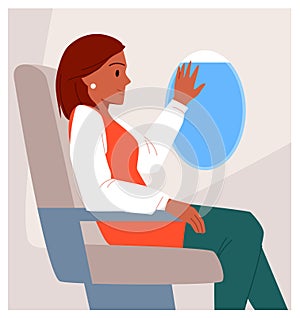 Passenger sitting by window, touching porthole blind to open or close illuminator