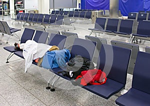 Passenger sleeps in an empty night airport after flight cancellation