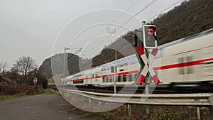 A passenger train passes a red warning sign