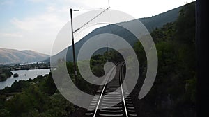 Passenger train passing through countryside on railroad. Traveling along railway tracks. Cargo train moving fast on railroad and t