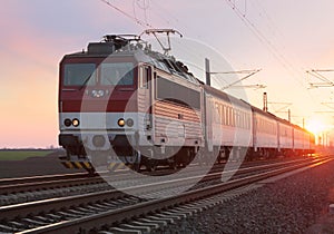 Passenger train on railway at sunset