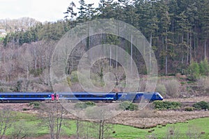 Passenger train speeding through forestry in Devon UK