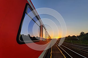 Passenger train stationed in a station in the middle of Carpathian mountains, Transylvania area, at sunset.